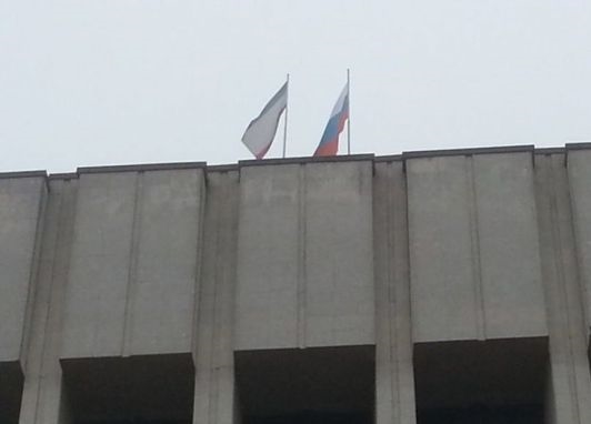 Представители самообороны развешивают в Симферополе флаги РФ