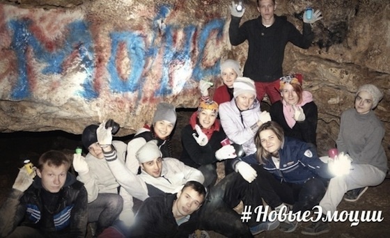 Молодые люди на фоне граффити в пещере Греве